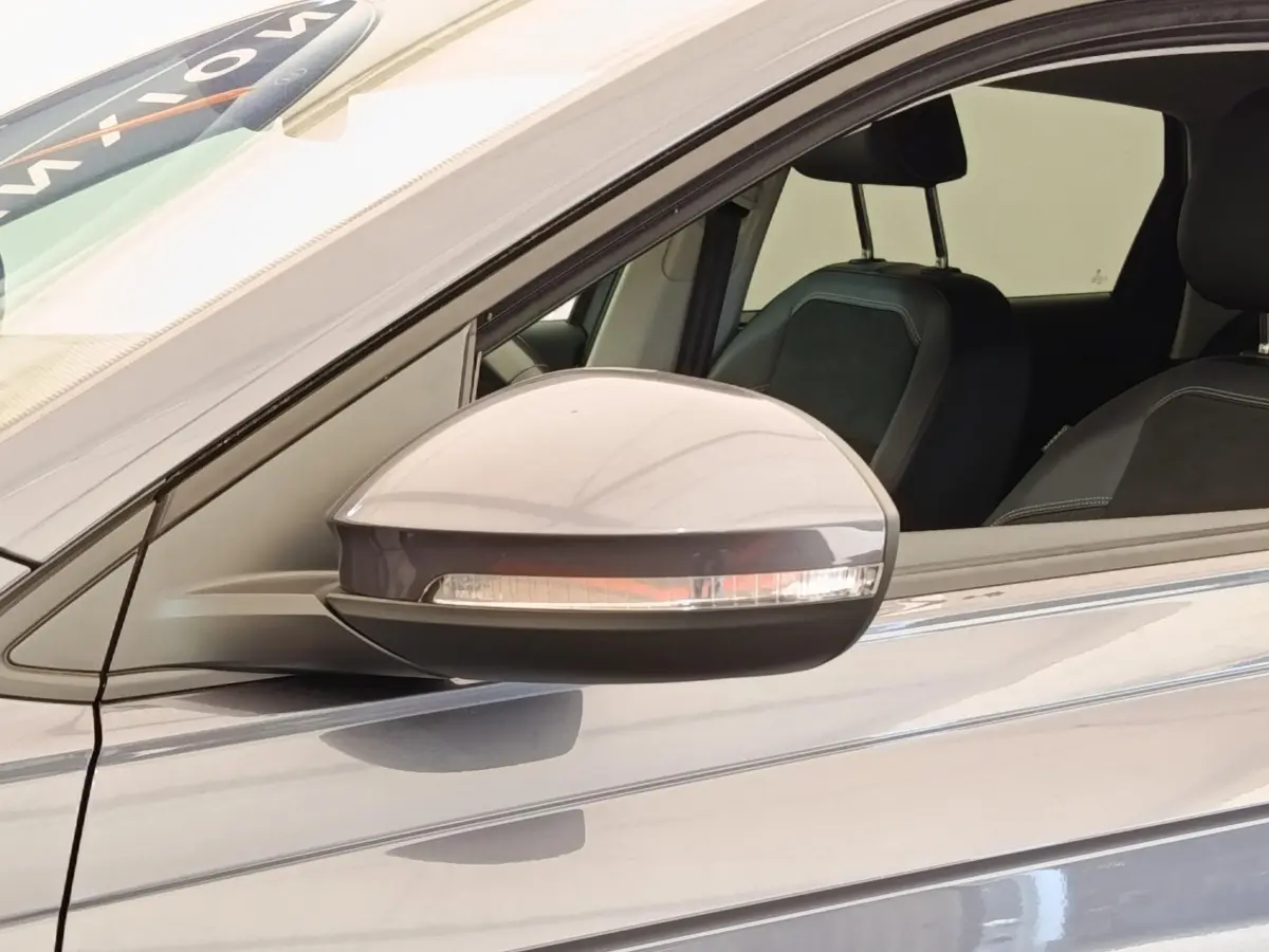 Rétroviseur droit gris foncé du Volkswagen Taigo 1.5 TSI 150 DSG Style 2023 avec siège avant visible.