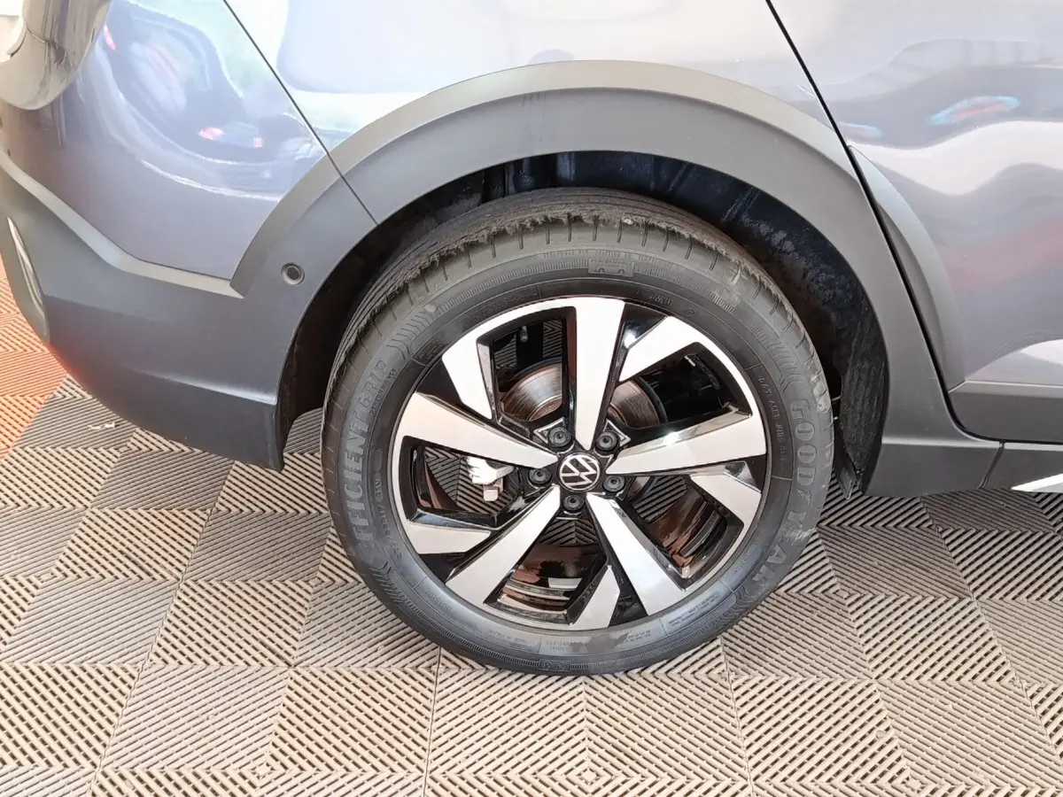 Gros plan sur la roue arrière droite gris foncé du Volkswagen Taigo 1.5 TSI 150 DSG Style avec jante alliage bicolore.