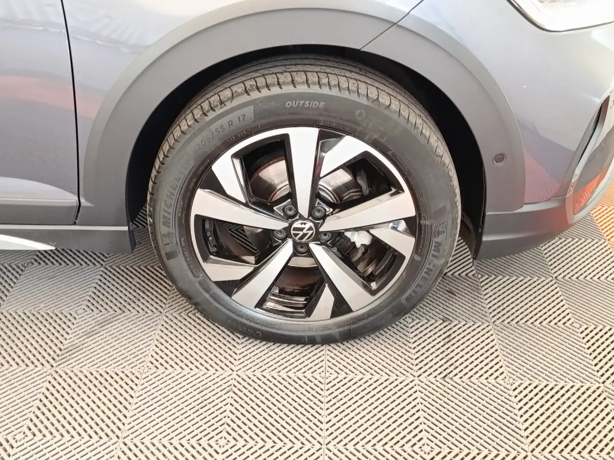 Gros plan sur la roue avant gauche et la jante en alliage du Volkswagen Taigo gris foncé 2023.