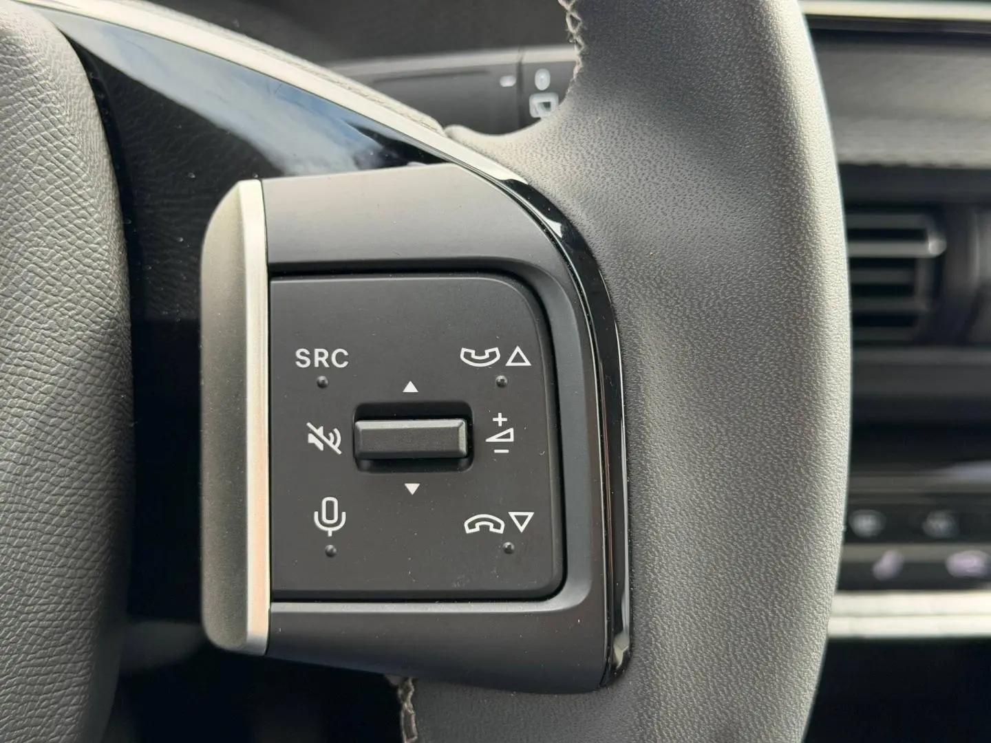 Gros plan sur les commandes multifonctions noires à gauche du volant du Citroën C3 2025, version 1.2 Turbo 100ch MAX.