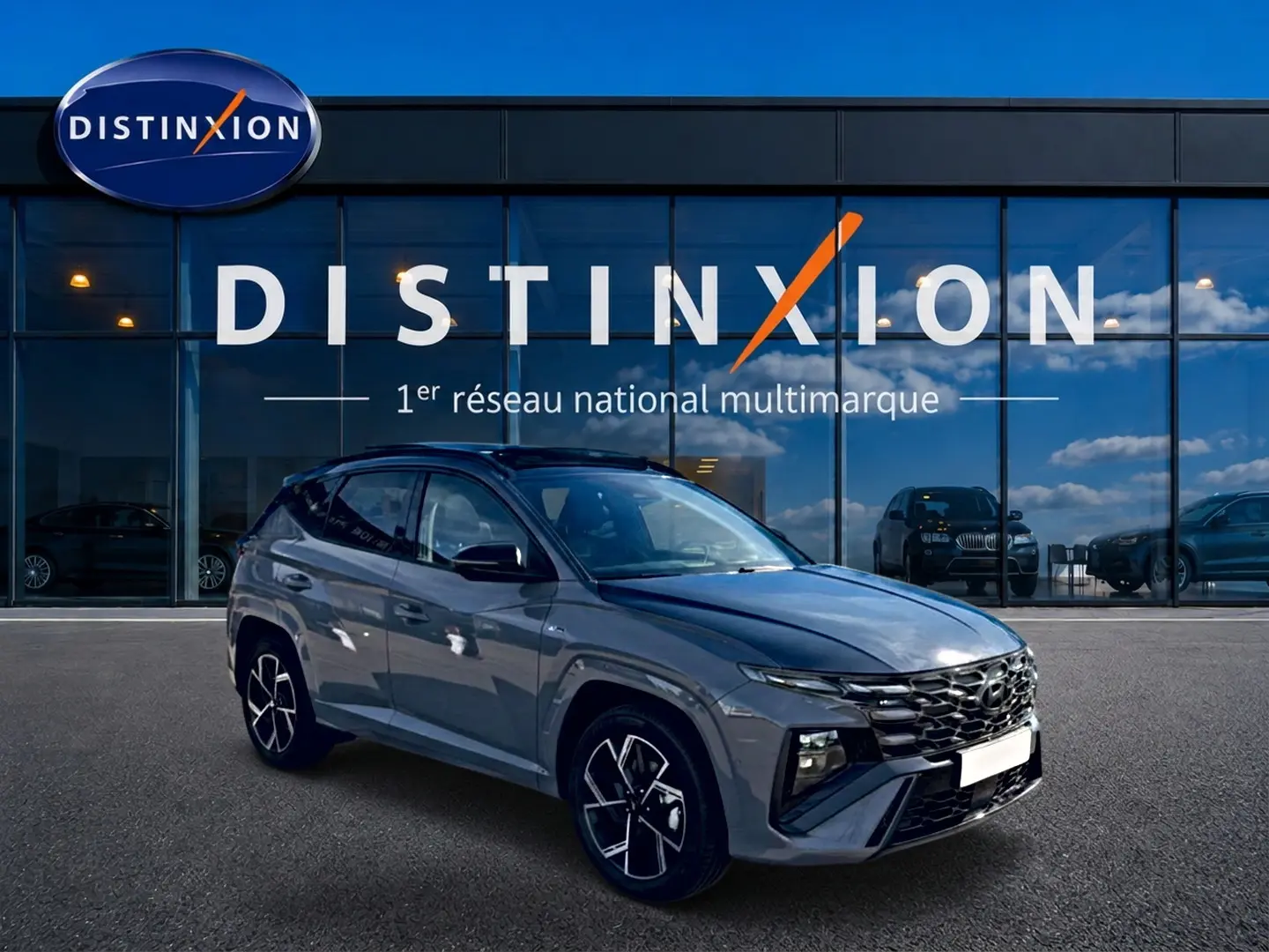 Hyundai Tucson 1.6 T-GDI hybride gris shadow en 3/4 avant droit devant vitrine Distinxion.