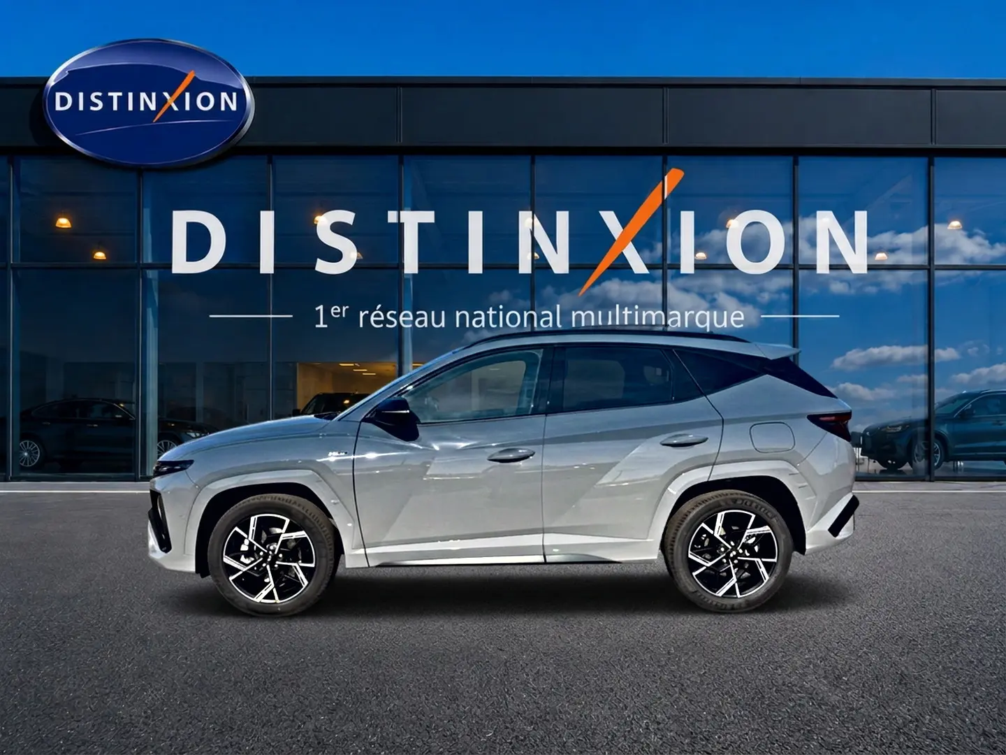 Hyundai Tucson 2026 gris shadow en profil droit, avec jantes alu noires et toit panoramique visible.