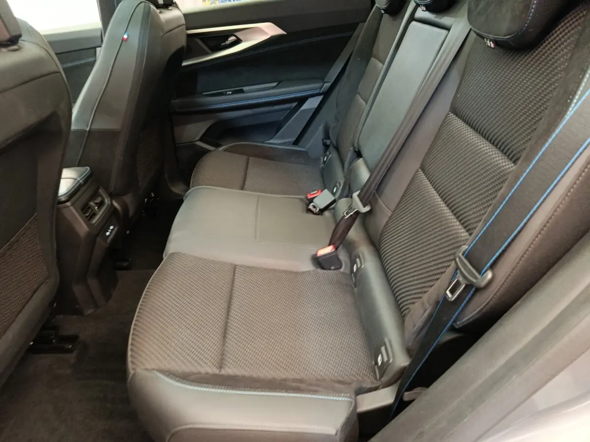 Vue côté droit de la banquette arrière noire avec surpiqûres bleues du Renault Austral Iconic Esprit Alpine 2024.