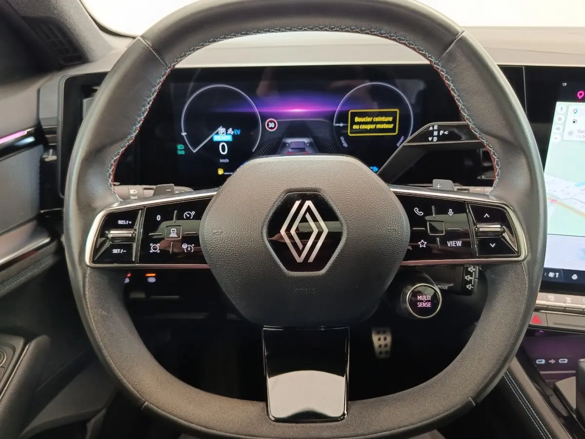 Vue rapprochée du volant en cuir suédé noir du Renault Austral 2024 avec commandes multifonctions et tableau de bord digital.