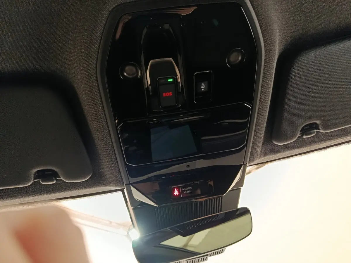 Vue intérieure en plongée du plafonnier noir brillant avec bouton SOS et indicateur airbag passager du Renault Austral gris clair.