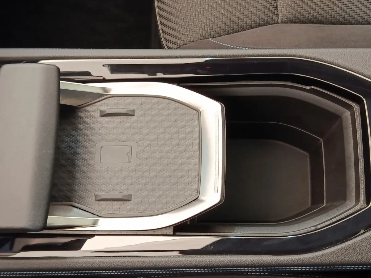 Vue plongeante sur la console centrale noire avec espace de rangement et accoudoir du Renault Austral Iconic Esprit Alpine E-Tech.