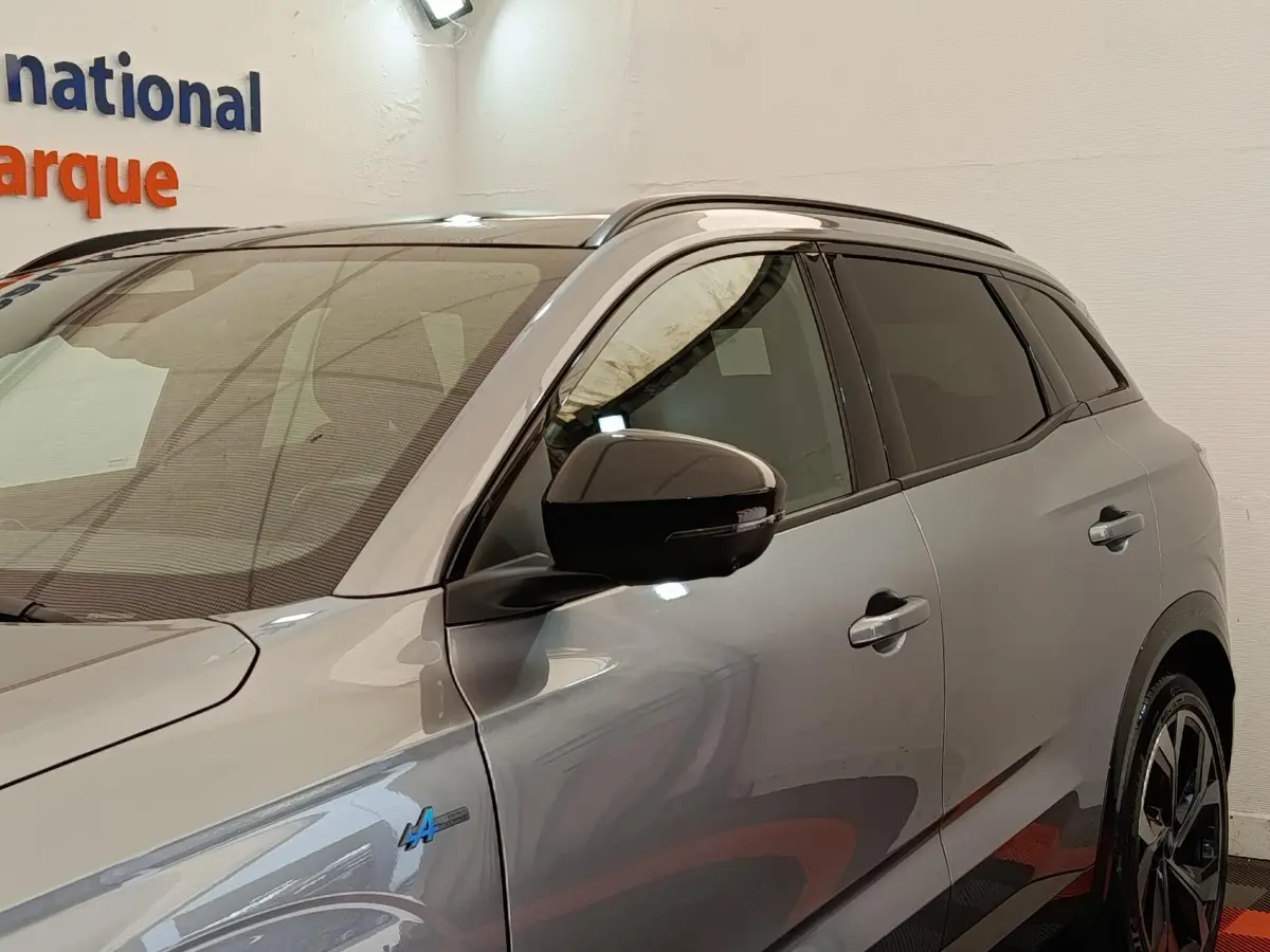 Vue de profil droit du Renault Austral gris clair Iconic Esprit Alpine E-Tech 2024 avec logo Alpine bleu sur l'aile avant.