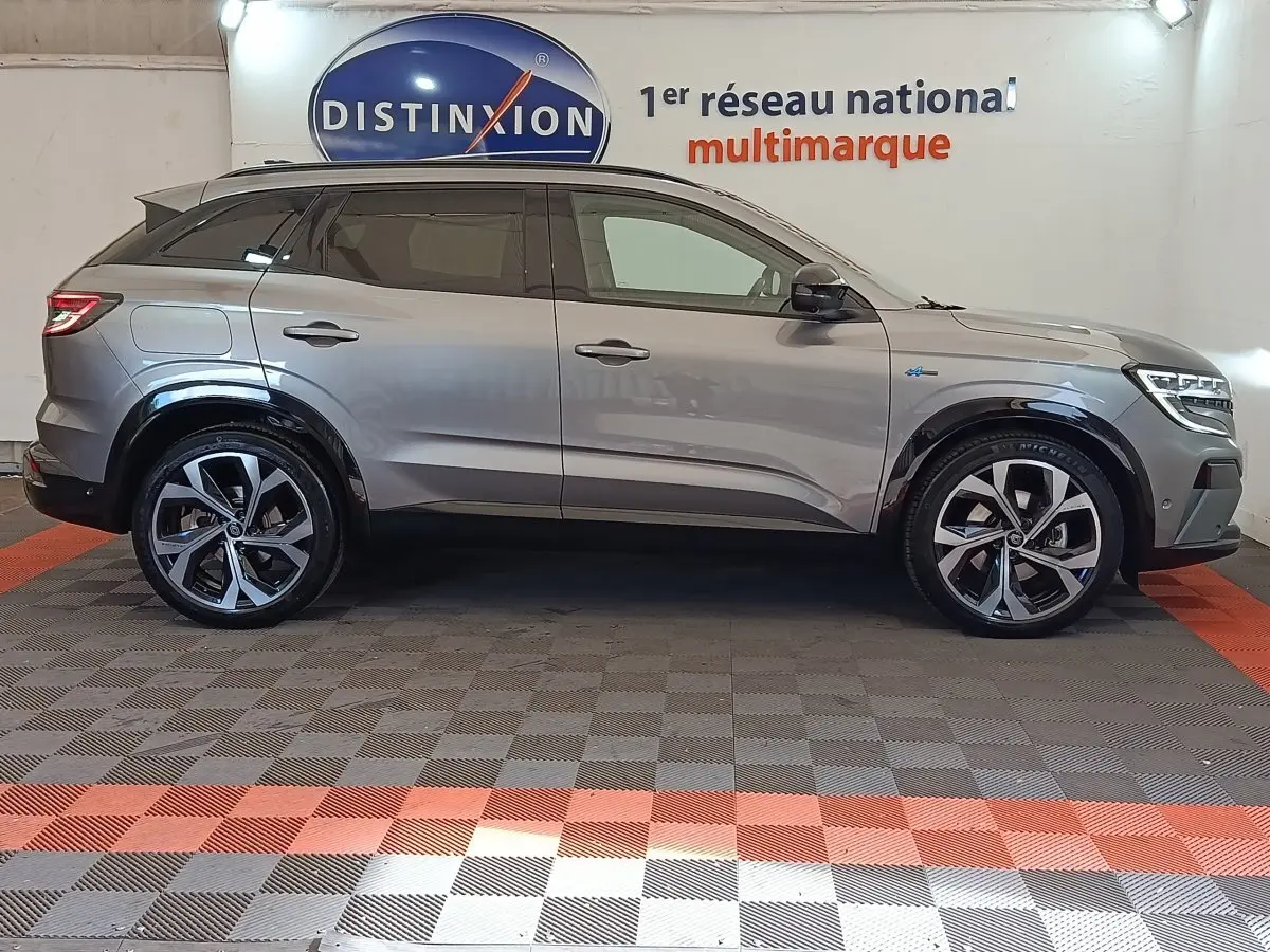 Profil droit d’un Renault Austral gris clair 2024 avec jantes alliage distinctives et toit noir en showroom.