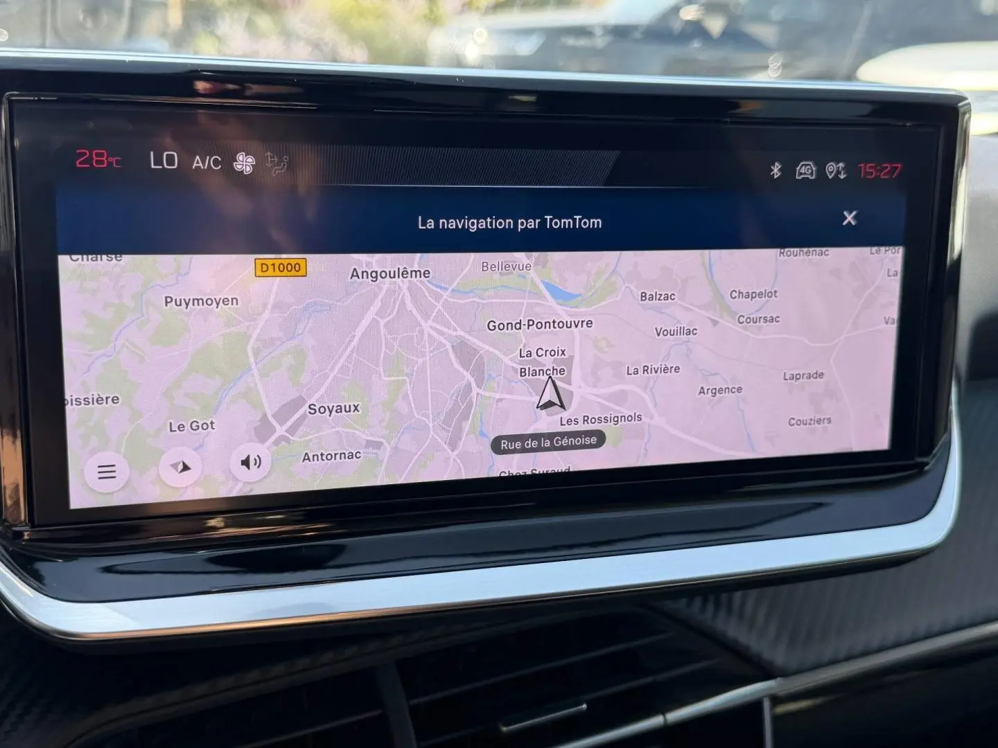 Écran tactile central de navigation TomTom dans l’habitacle d’une Peugeot 208 gris Artense, vue de face rapprochée.