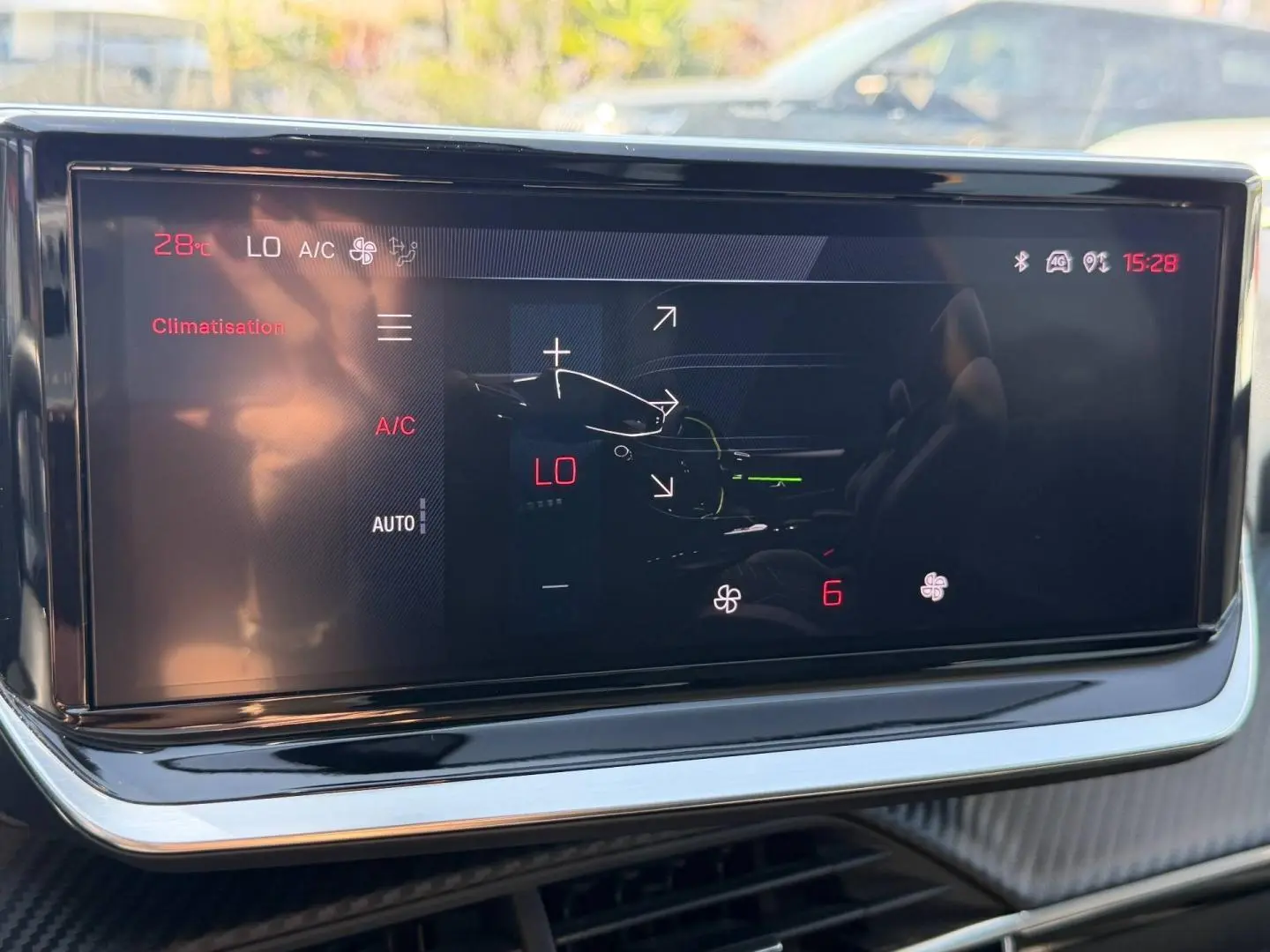 Écran tactile de la climatisation dans l'habitacle du Peugeot 208, affichant la température et les réglages.