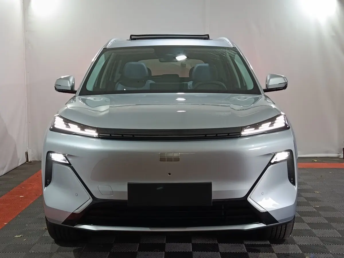 Vue frontale d'un Geely STARRAY gris clair avec phares LED fins et toit ouvrant partiellement ouvert.