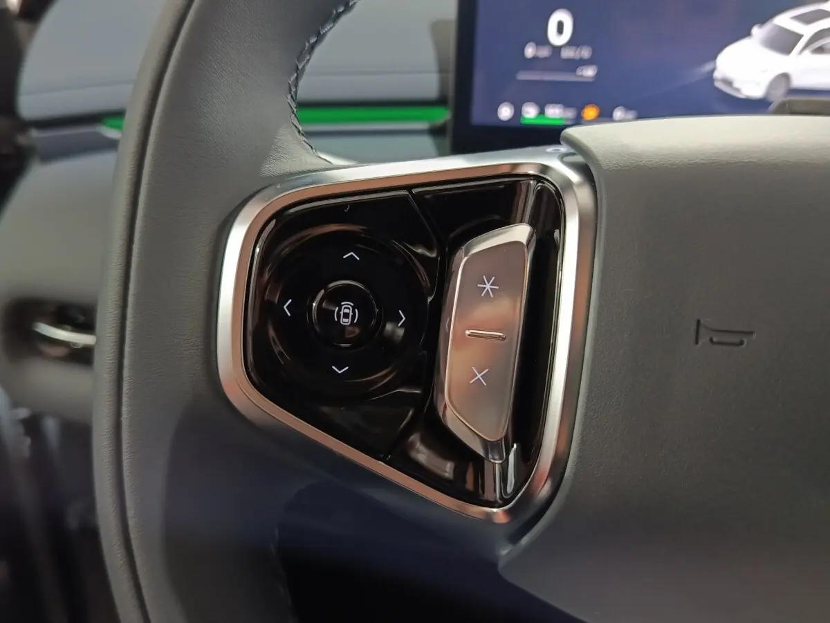 Gros plan sur les commandes multifonctions noires et argentées du volant gris du Geely STARRAY hybride rechargeable.