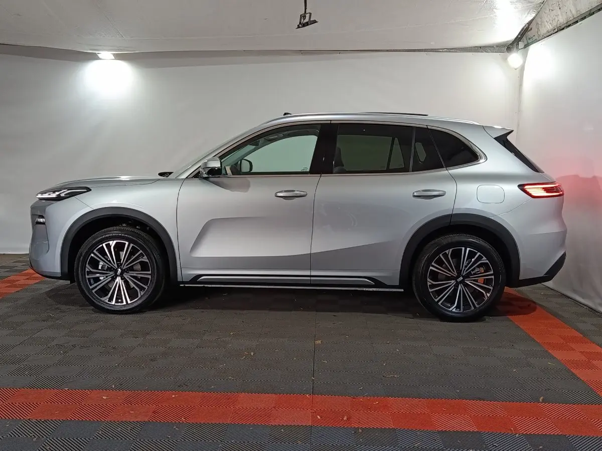 Vue latérale droite du SUV hybride rechargeable Geely STARRAY 1.5 EM-I PHEV Max+ gris clair dans un studio.