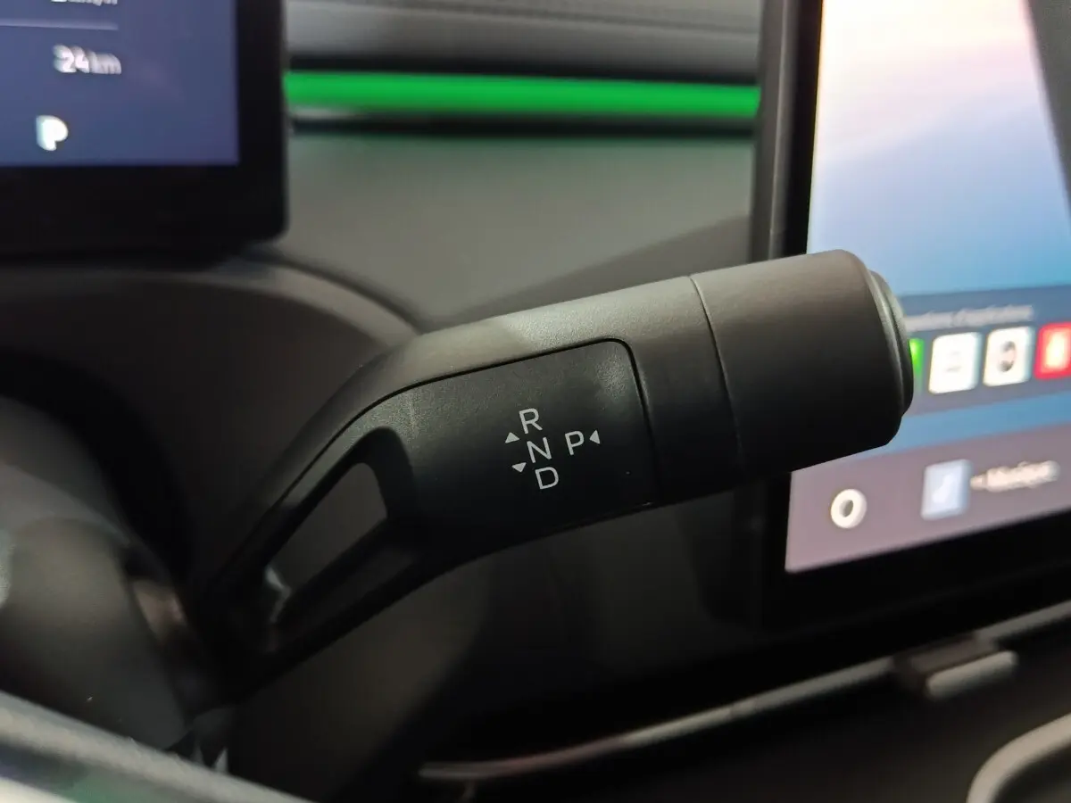 Gros plan sur la commande de boîte automatique noire dans l'habitacle du Geely STARRAY 1.5 EM-I PHEV Max+ gris clair.