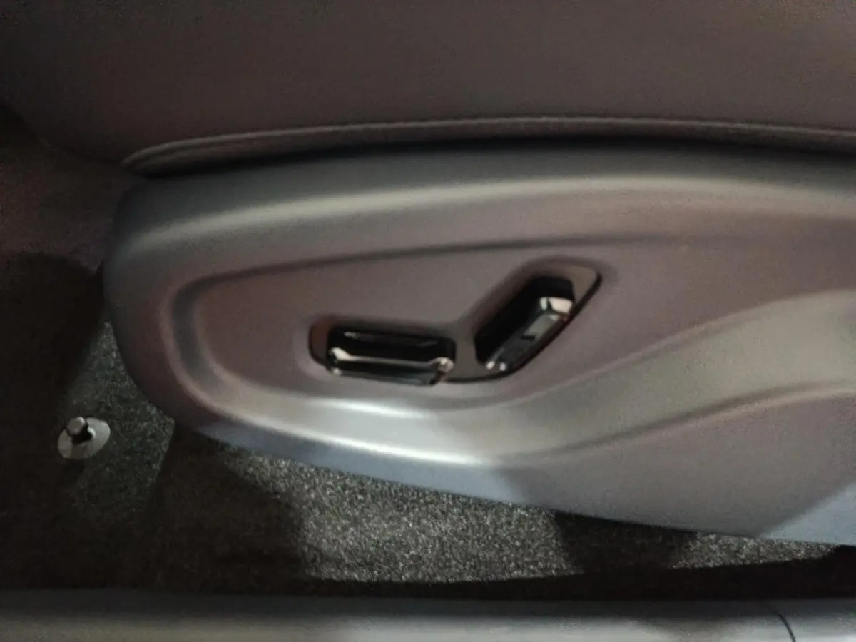 Gros plan sur les commandes électriques du siège côté conducteur du Geely STARRAY gris clair.