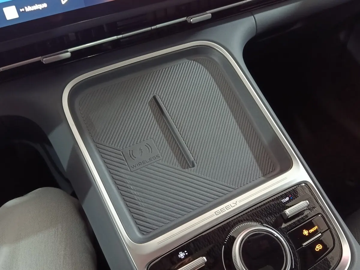 Vue rapprochée de la console centrale grise du Geely STARRAY 2026 avec zone de recharge sans fil et commandes climatisation.
