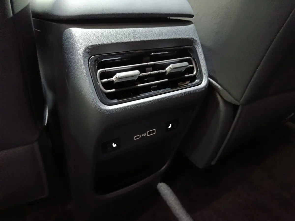 Vue rapprochée de la console arrière noire du GEELY STARRAY 1.5 EM-I PHEV Max+ avec aérateurs et ports USB.