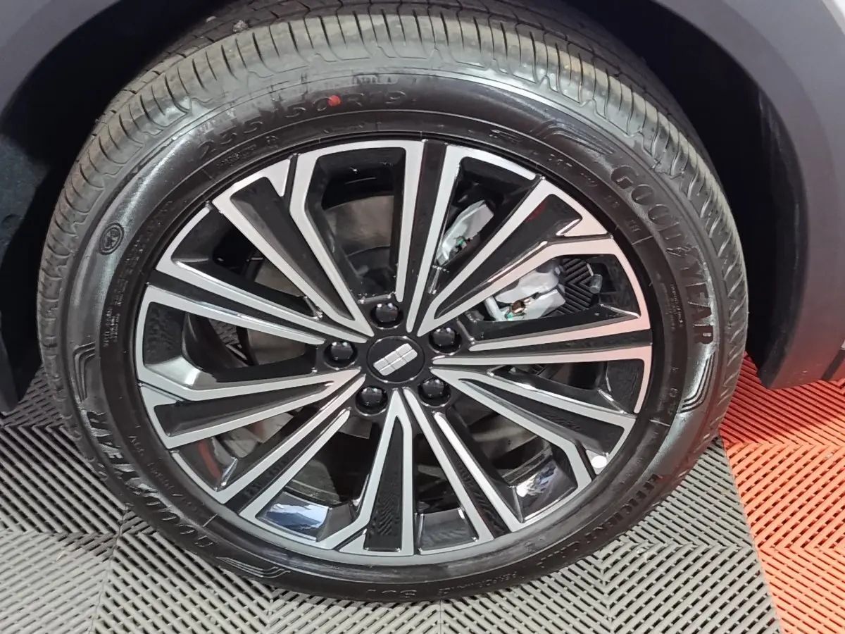 Gros plan sur la roue avant droite du Geely STARRAY gris clair, avec jante alliage noire et argentée au design moderne.