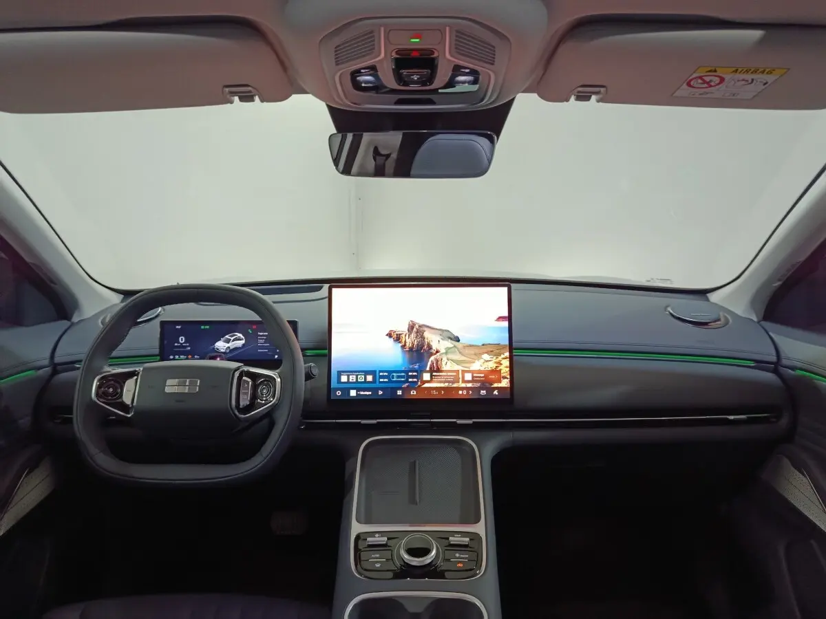 Vue frontale de l’habitacle du Geely STARRAY gris clair, avec grand écran tactile central et volant multifonctions.