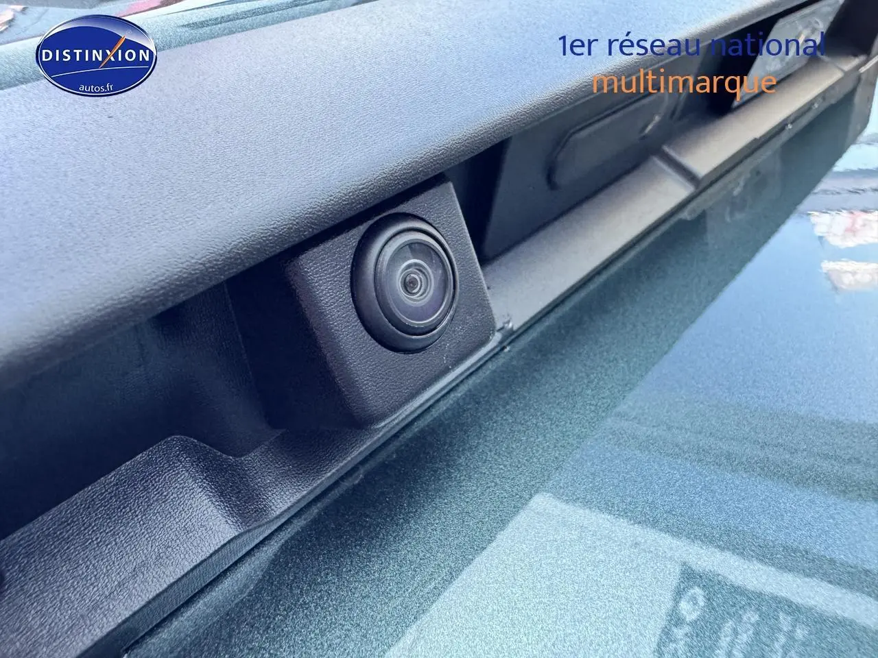 Gros plan sur la caméra de recul intégrée sur la porte arrière du Dacia Duster vert cèdre 2025.