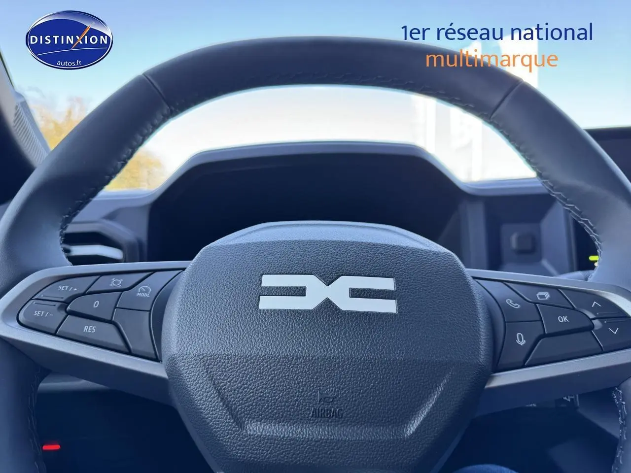 Gros plan sur le volant multifonction noir du Dacia Duster 2025, avec commandes intégrées visibles.