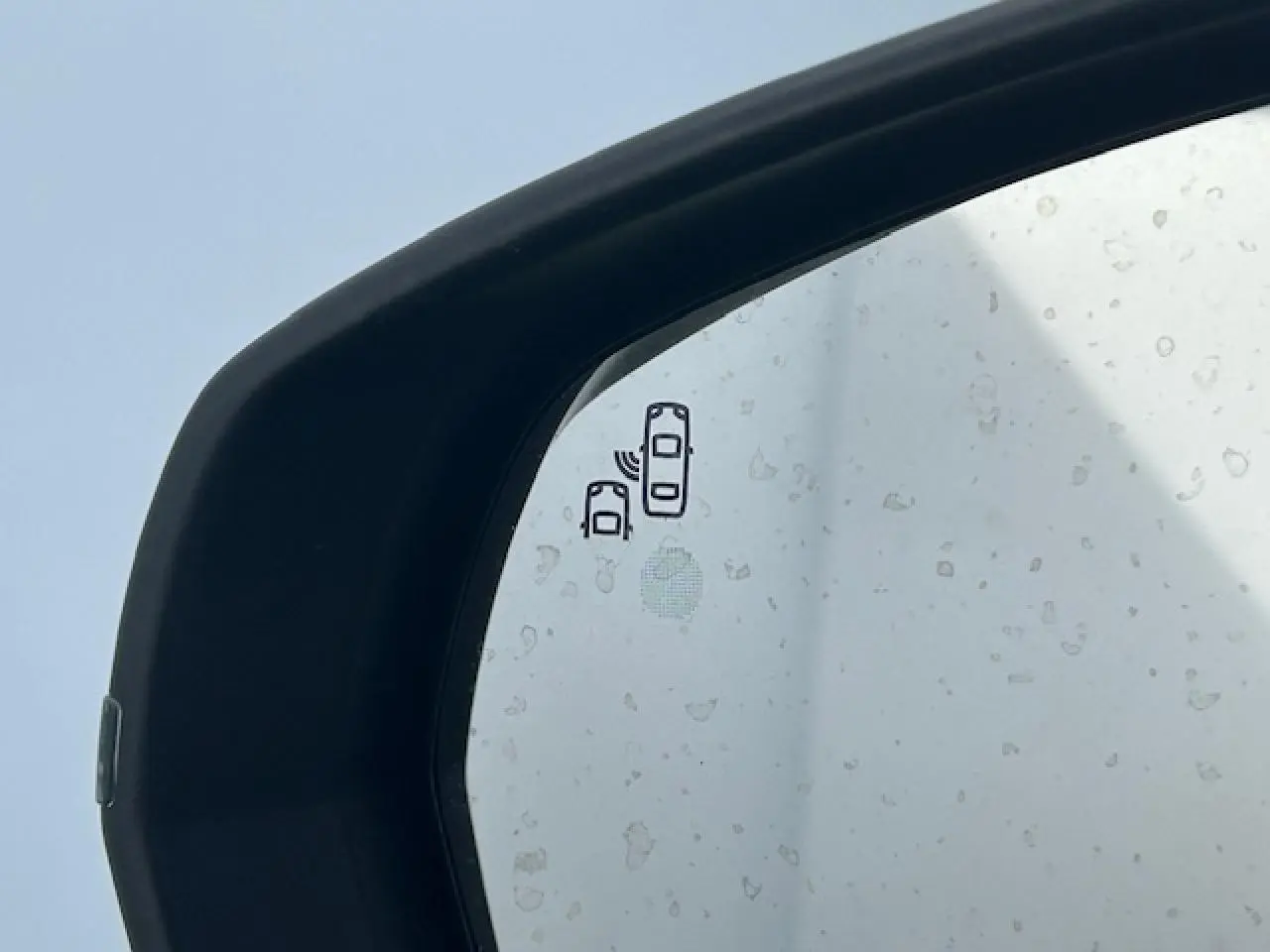 Gros plan sur le rétroviseur extérieur noir brillant du Citroën C5 Aircross bleu Eclipse Metal avec indicateur d'angle mort.