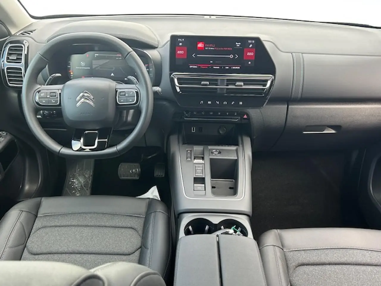 Vue intérieure avant du Citroën C5 Aircross 2025 avec tableau de bord numérique et volant cuir gris Métropolitan Grey.