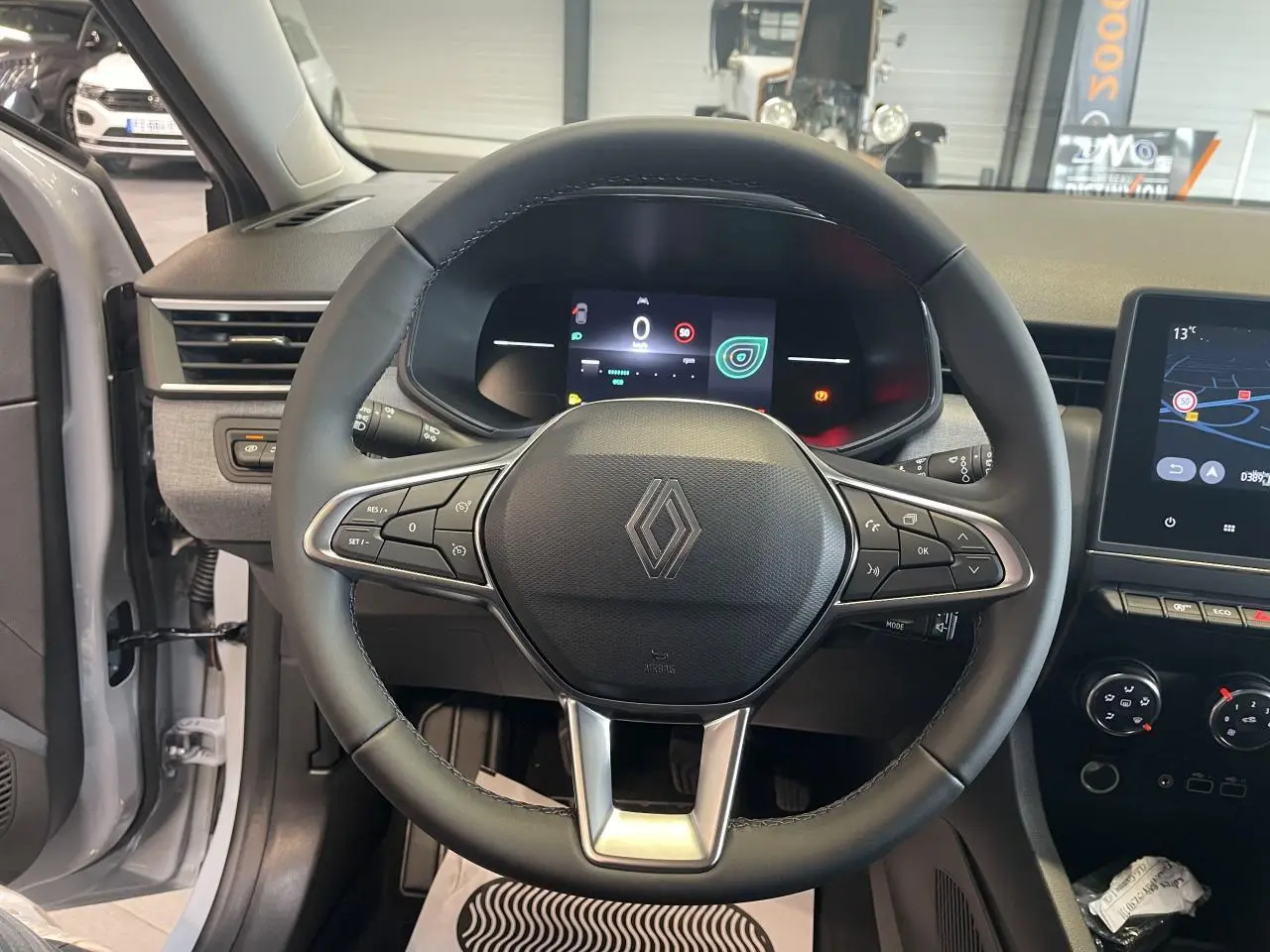 Vue intérieure centrée sur le volant noir de la Renault Clio 1.5 Blue dCi 2025, avec tableau de bord numérique et écran tactile.