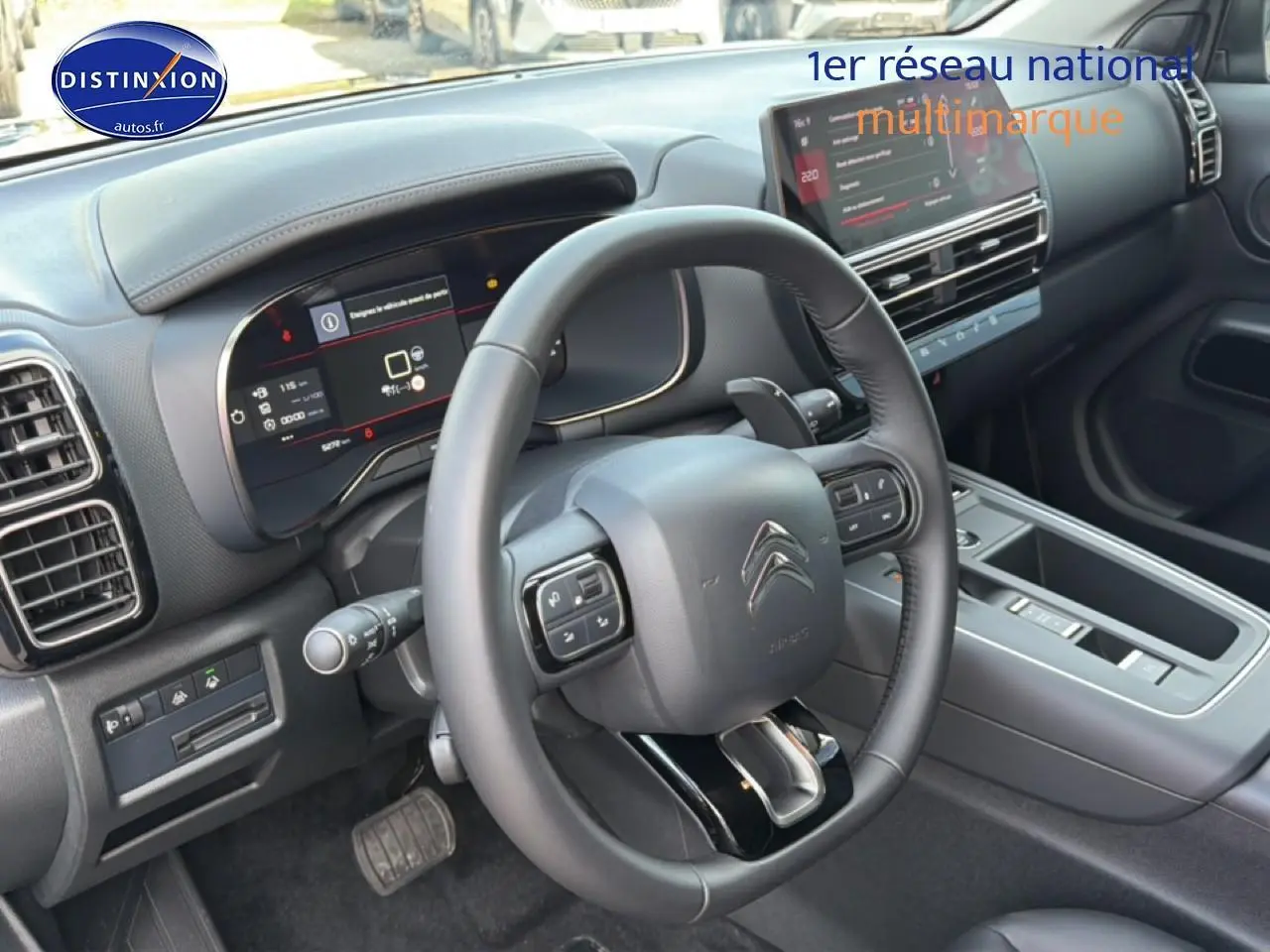 Vue intérieure côté conducteur du tableau de bord et volant cuir noir du Citroën C5 Aircross 2025.