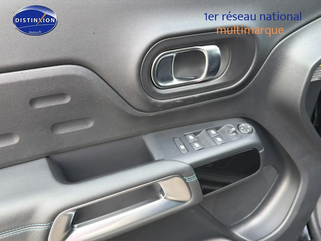 Gros plan sur la porte avant gauche noire du Citroën C5 Aircross avec commandes des vitres et poignée chromée.