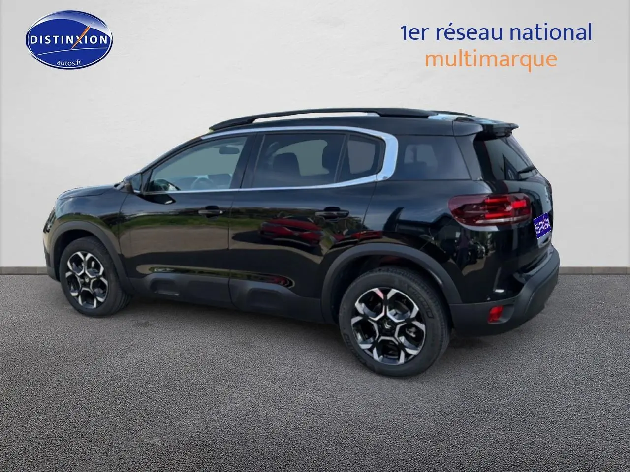 Vue latérale droite d'un Citroën C5 Aircross noir Perla Nera avec jantes alliage et barres de toit visibles.