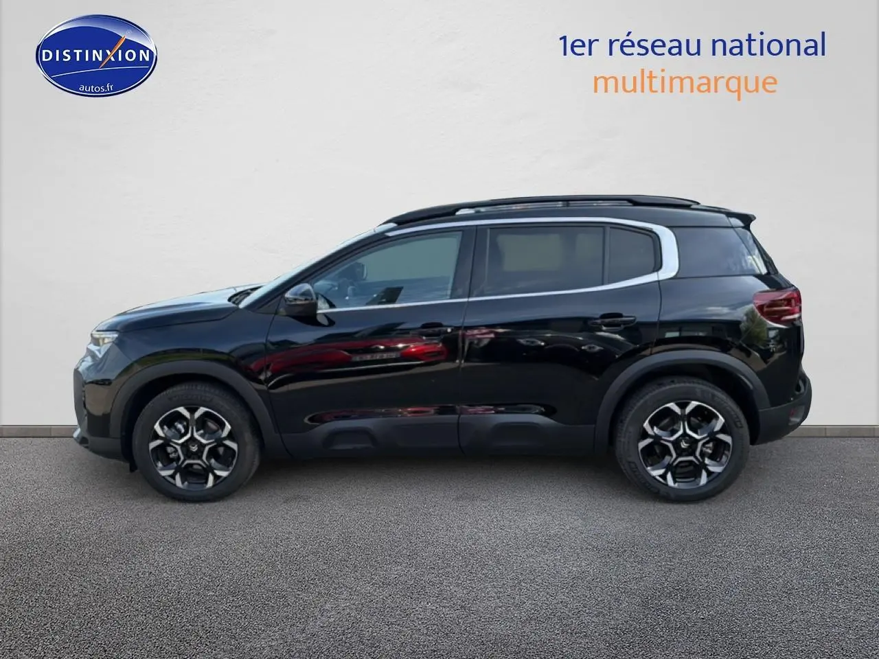 Profil côté gauche du SUV Citroën C5 Aircross noir Perla Nera avec jantes alu et barres de toit visibles.