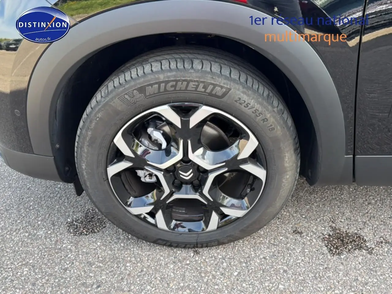 Gros plan sur la roue avant gauche du Citroën C5 Aircross noir Perla Nera avec jante alliage bicolore et pneu Michelin.