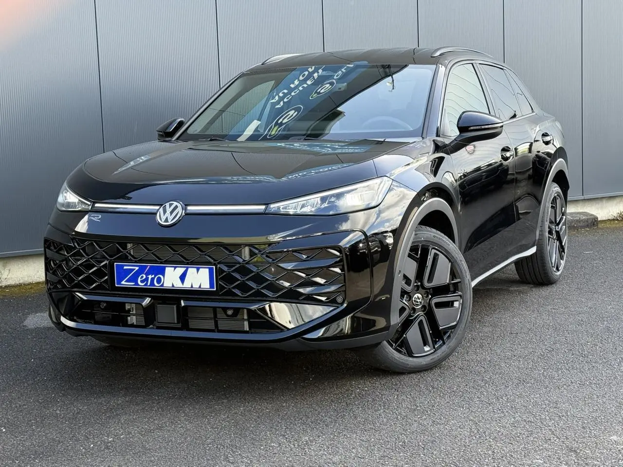 Volkswagen T-Roc 2026 noir ébène en 3/4 avant droit avec jantes noires et projecteurs IQ.Light allumés.