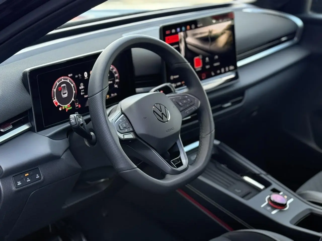 Vue intérieure du tableau de bord et volant noir du Volkswagen T-Roc 2026 avec écran digital et console centrale moderne.