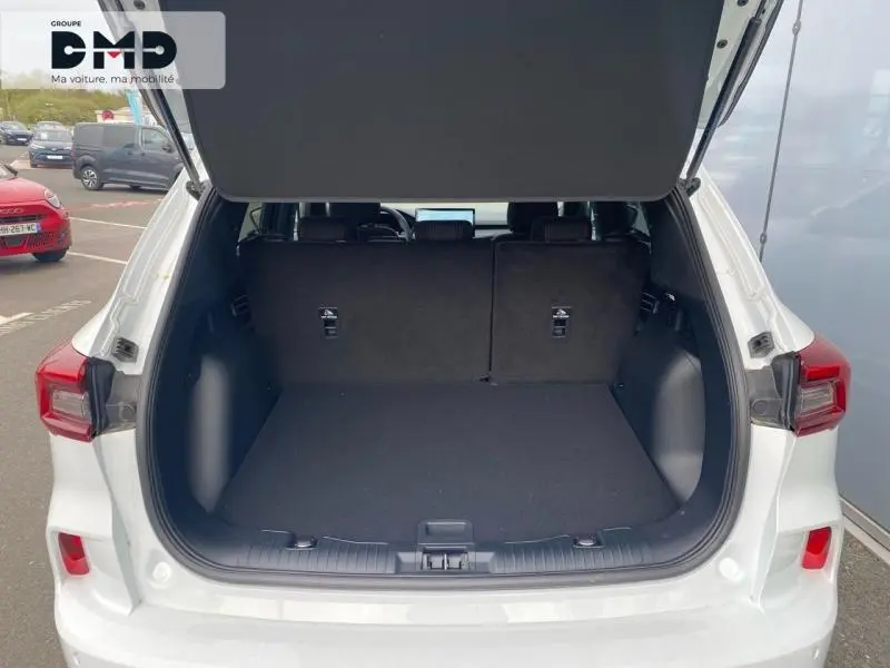 Coffre ouvert vu de l'arrière d'un Ford Kuga blanc Glacier, montrant l'espace de chargement et la banquette arrière noire.