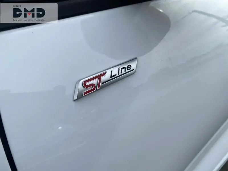 Gros plan sur l'emblème ST Line rouge et noir sur la carrosserie blanche Glacier d'un Ford Kuga 2026.