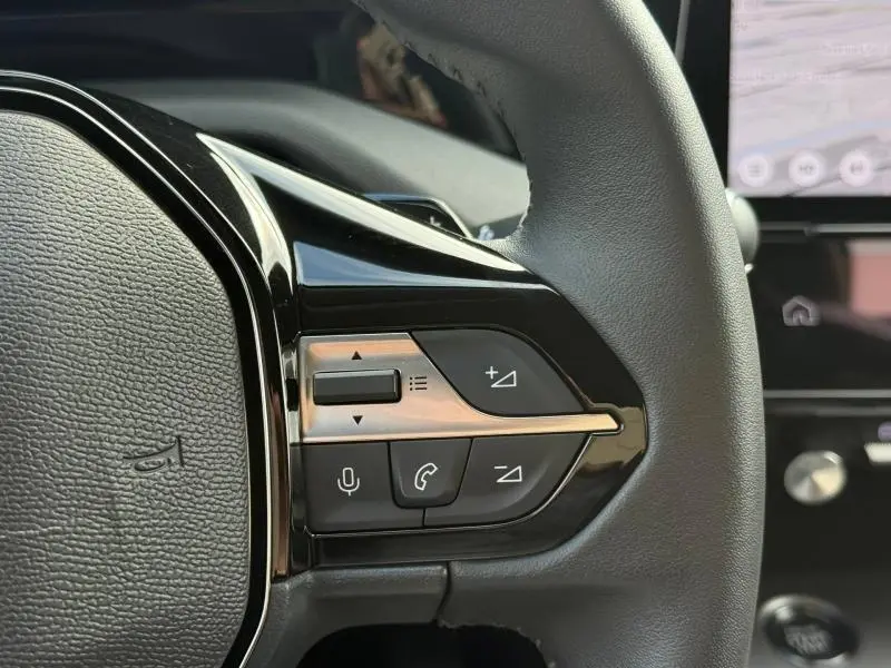 Gros plan sur les commandes multifonctions côté droit du volant noir de la Peugeot 308 1.5 BlueHDi 2024.
