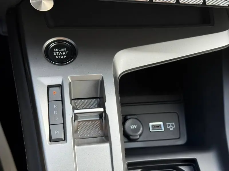 Détail de la console centrale de la Peugeot 308 2024 avec bouton start/stop, commande de boîte auto et prises 12V et USB.