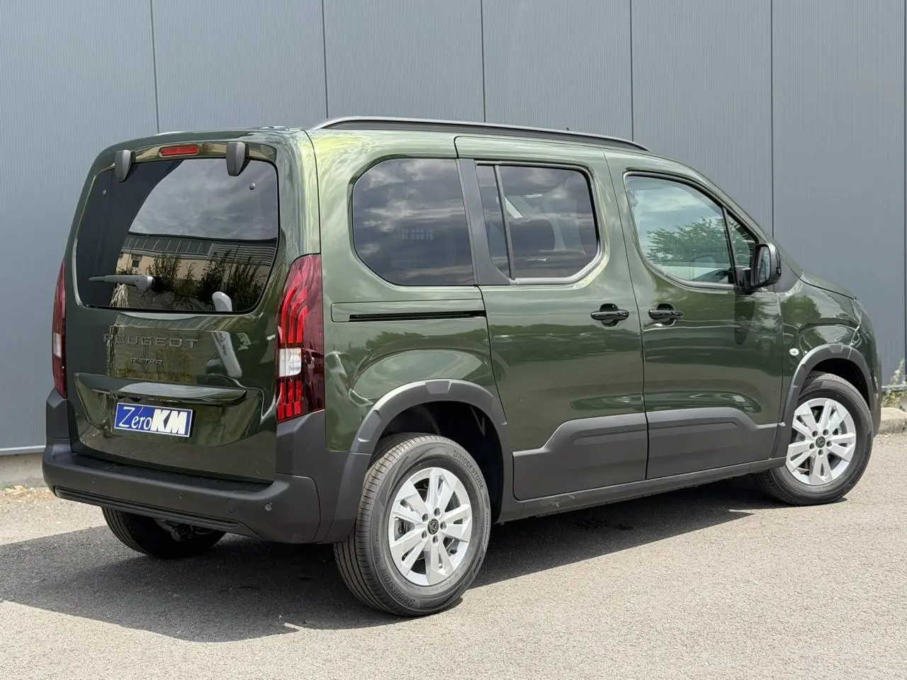 Vue 3/4 arrière droit du Peugeot Rifter 2026 vert Sirkka avec portes coulissantes et jantes alu 16 pouces.