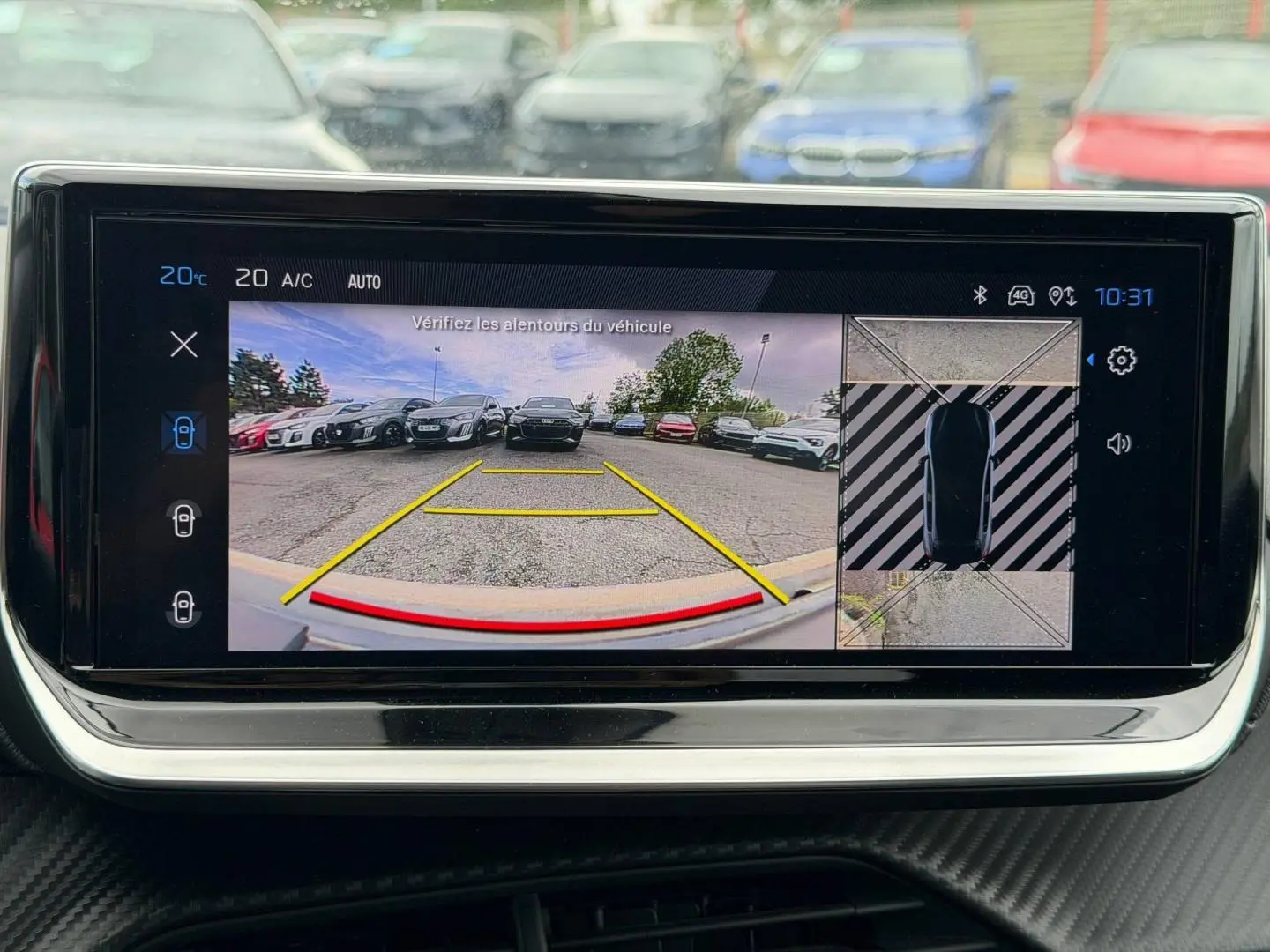 Écran tactile intérieur montrant la caméra de recul et vue 360° du stationnement d’une Peugeot 208 noire.