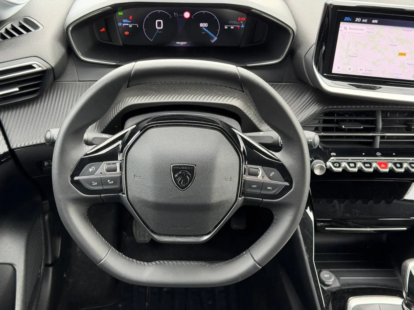 Vue rapprochée du volant multifonction noir et du tableau de bord numérique de la Peugeot 208 1.2 100ch Allure 2025.