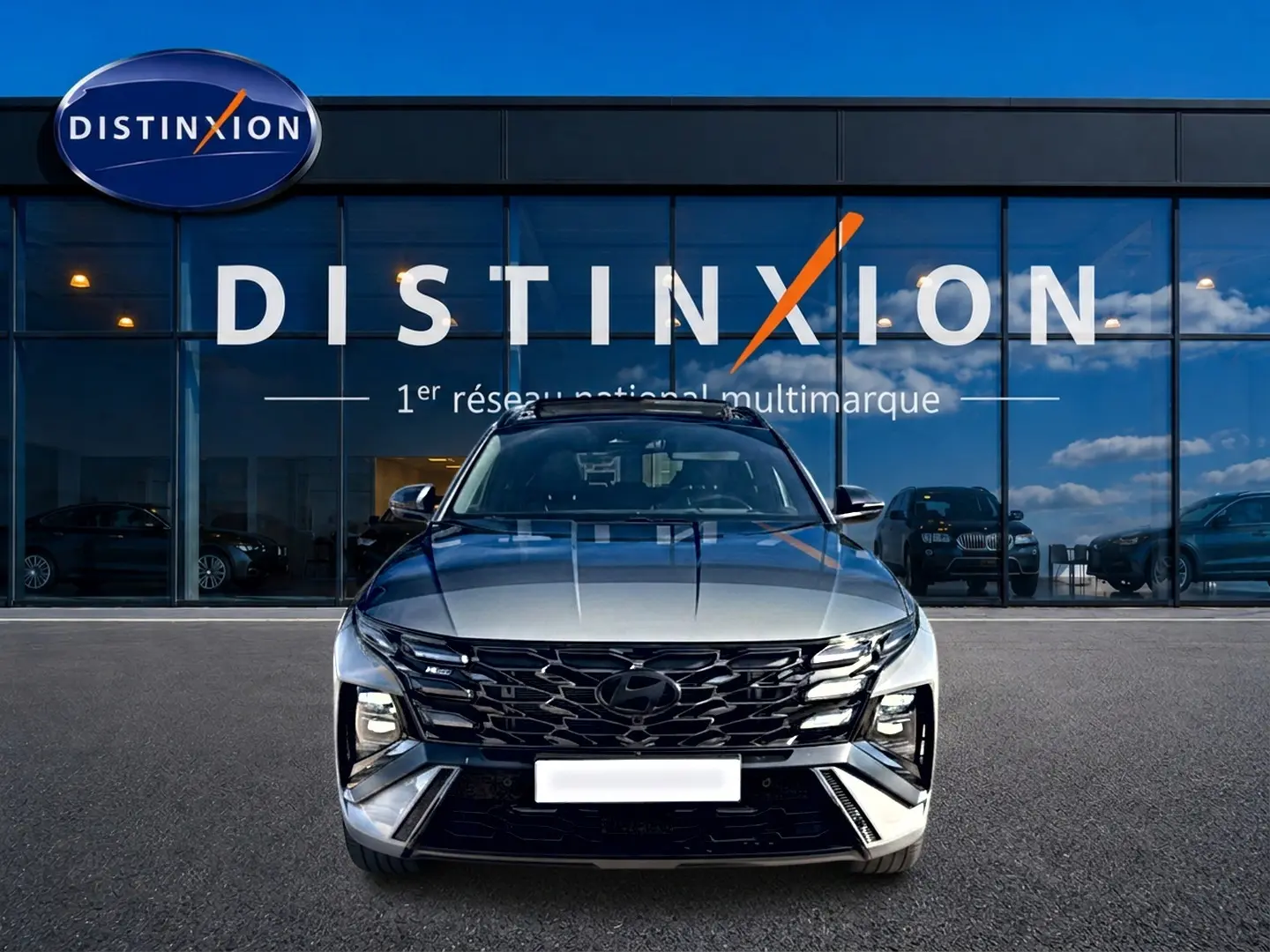 Vue avant d'un Hyundai Tucson 1.6 t-gdi hybride gris shadow avec calandre noire et phares LED distinctifs.