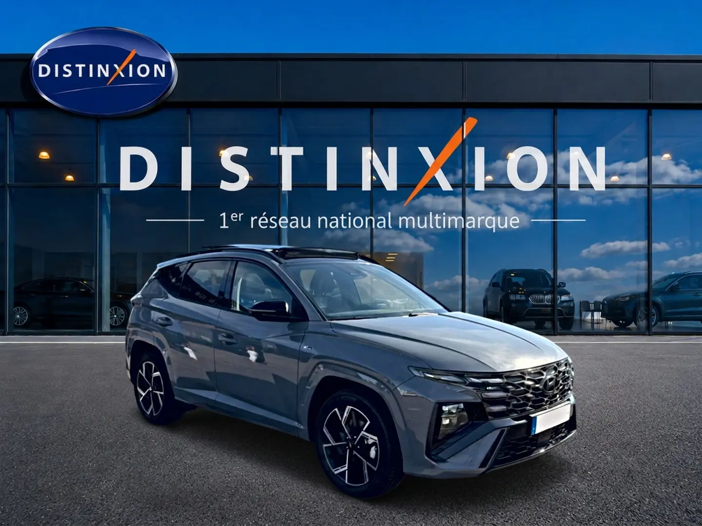 Hyundai Tucson 1.6 T-GDI hybride gris Shadow en 3/4 avant, avec calandre noire et jantes alu distinctives.