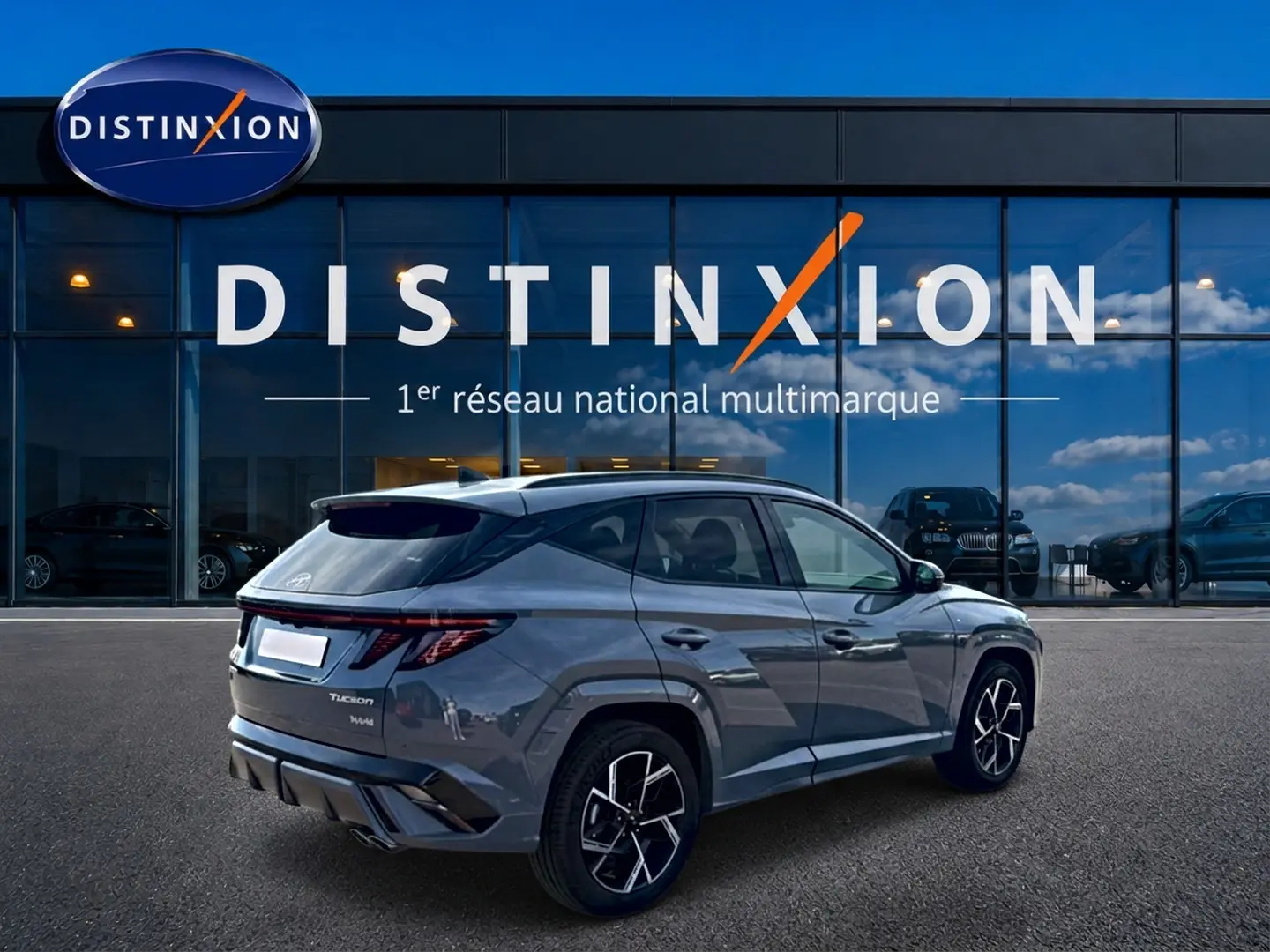 Vue 3/4 arrière droite d’un Hyundai Tucson 1.6 t-gdi hybride en gris shadow avec jantes alu et feux LED distinctifs.
