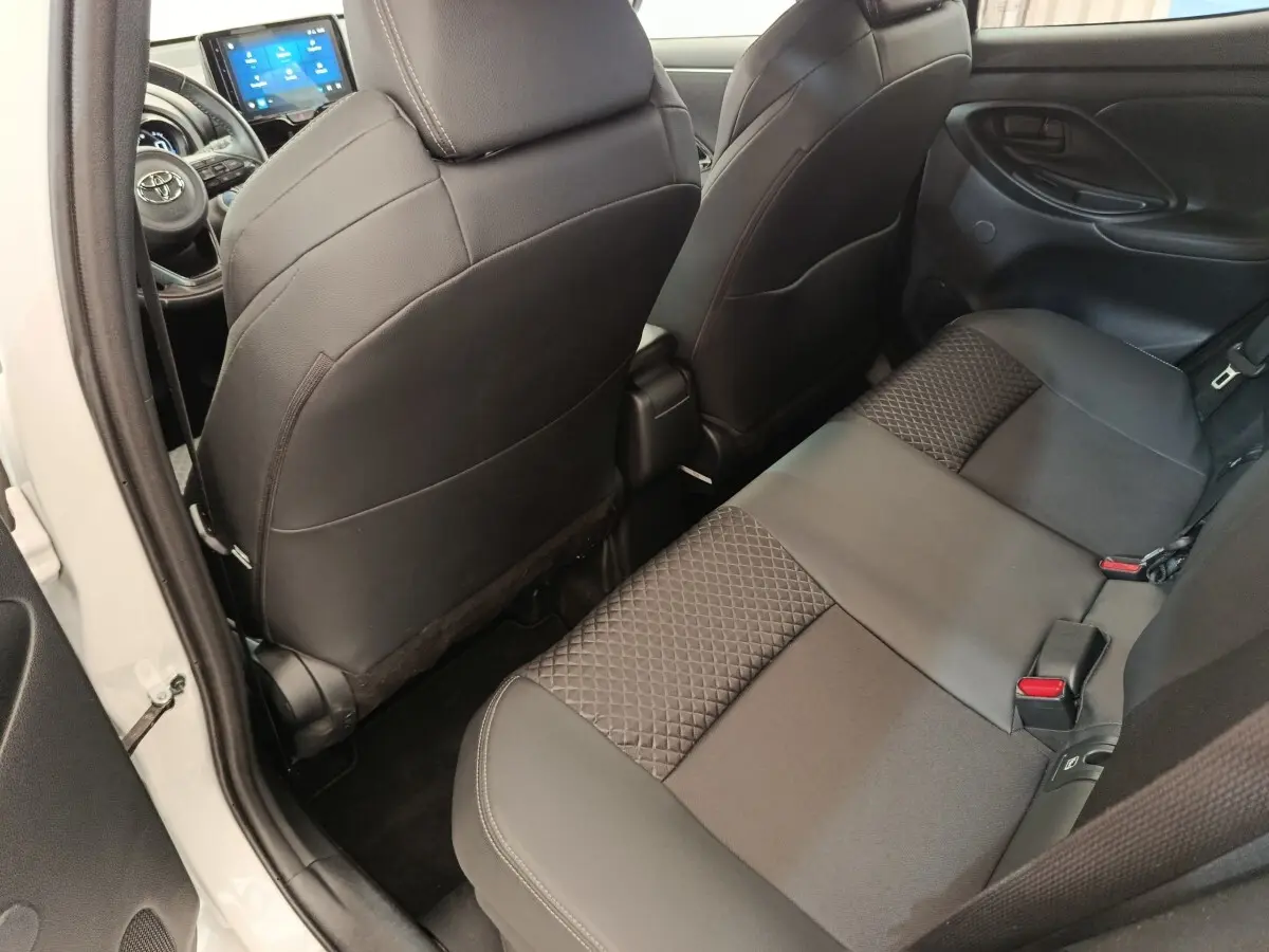 Vue intérieure arrière côté gauche de la Toyota Yaris Hybride 116h Collection 2022, sièges noirs avec motifs géométriques.