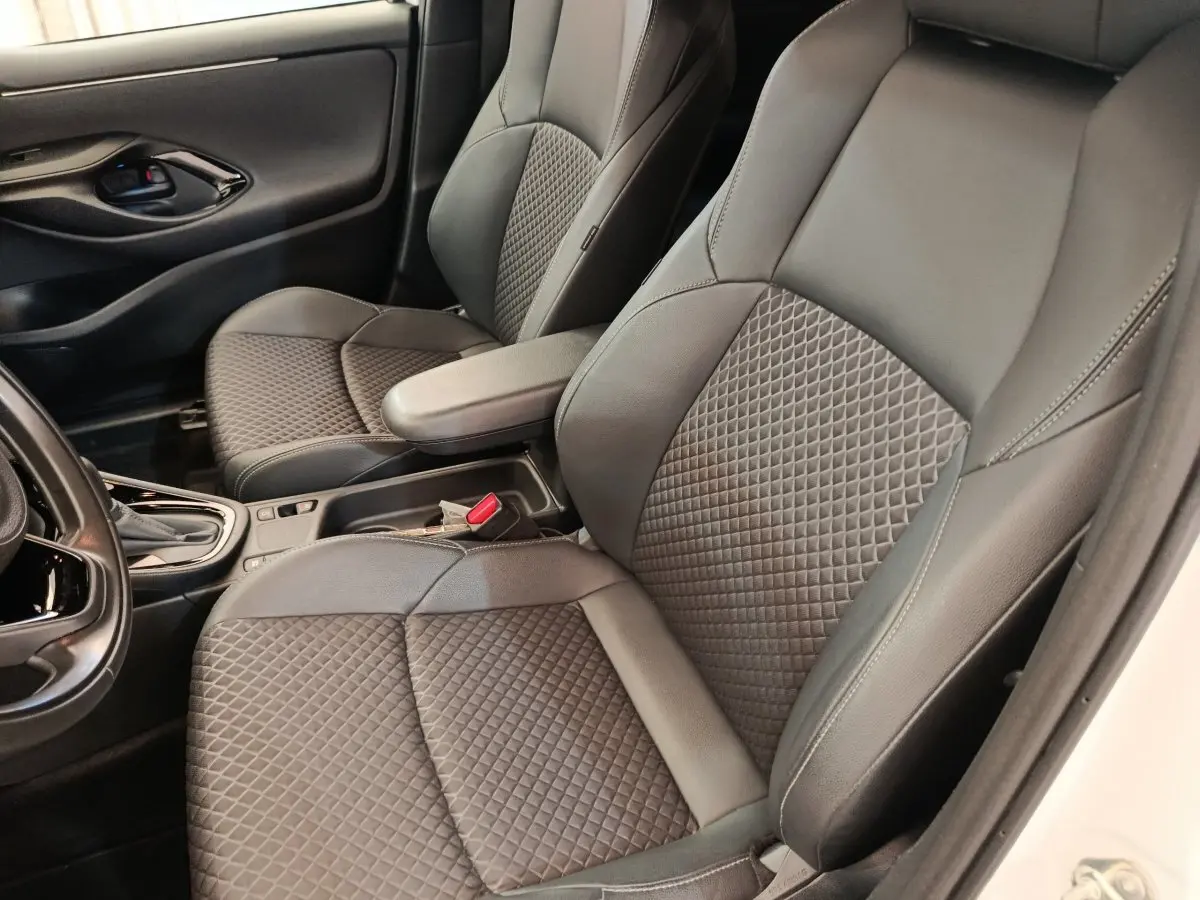 Vue intérieure côté droit des sièges avant en cuir noir matelassé de la Toyota Yaris Hybride 116h Collection blanche 2022.