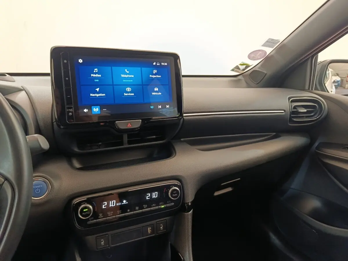 Vue intérieure côté passager de la Toyota Yaris Hybride 116h 2022, avec écran tactile central et climatisation bi-zone.