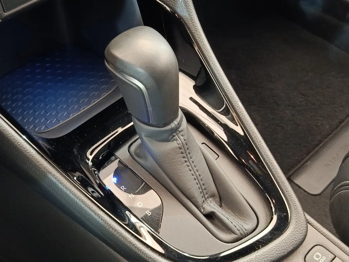 Le levier de vitesses automatique en cuir noir de la Toyota Yaris Hybride 116h, vue rapprochée de la console centrale.
