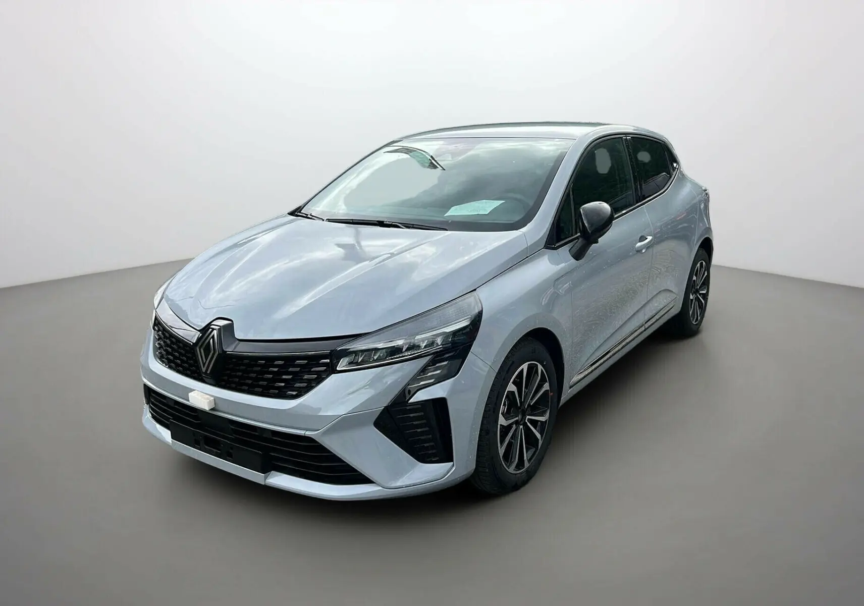 Renault Clio V TCE 90 TECHNO 2025 gris rafale vue 3/4 avant avec calandre noire et jantes alliage distinctives